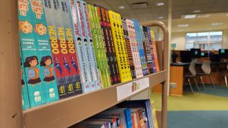 Pages for All Ages: Free books for youth while supplies last. Photo of books on a cart in the Children's Department. 